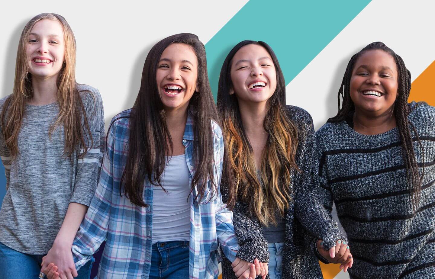 Four young girls holding hands, smiling walking toward the camera.